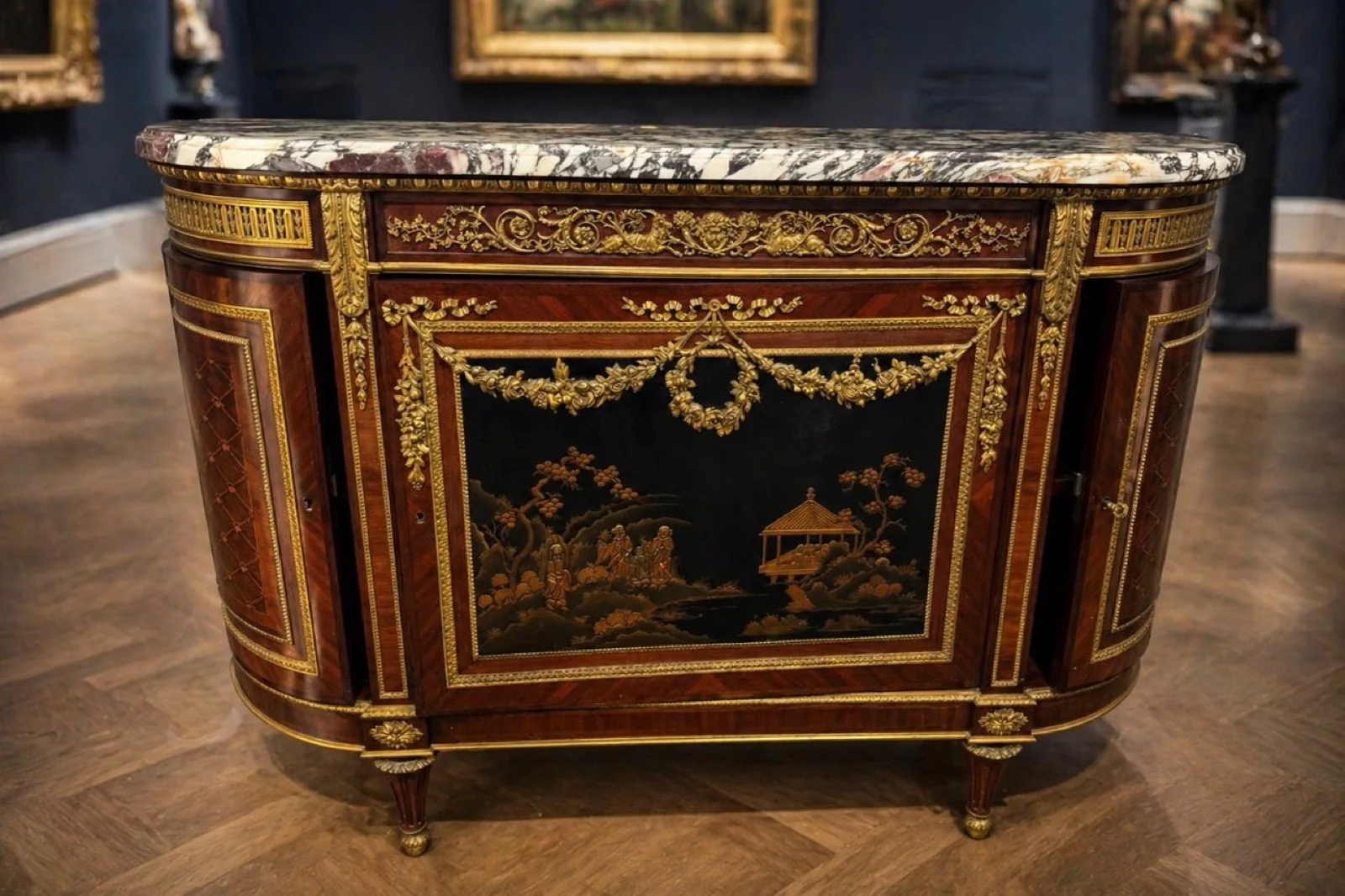An antique Louis XVI marble-topped gilt-mounted commode in a gallery