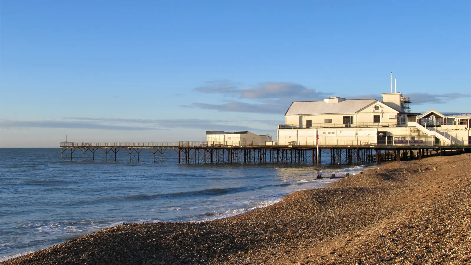 Bognor Regis pier and shingle beach in golden evening light