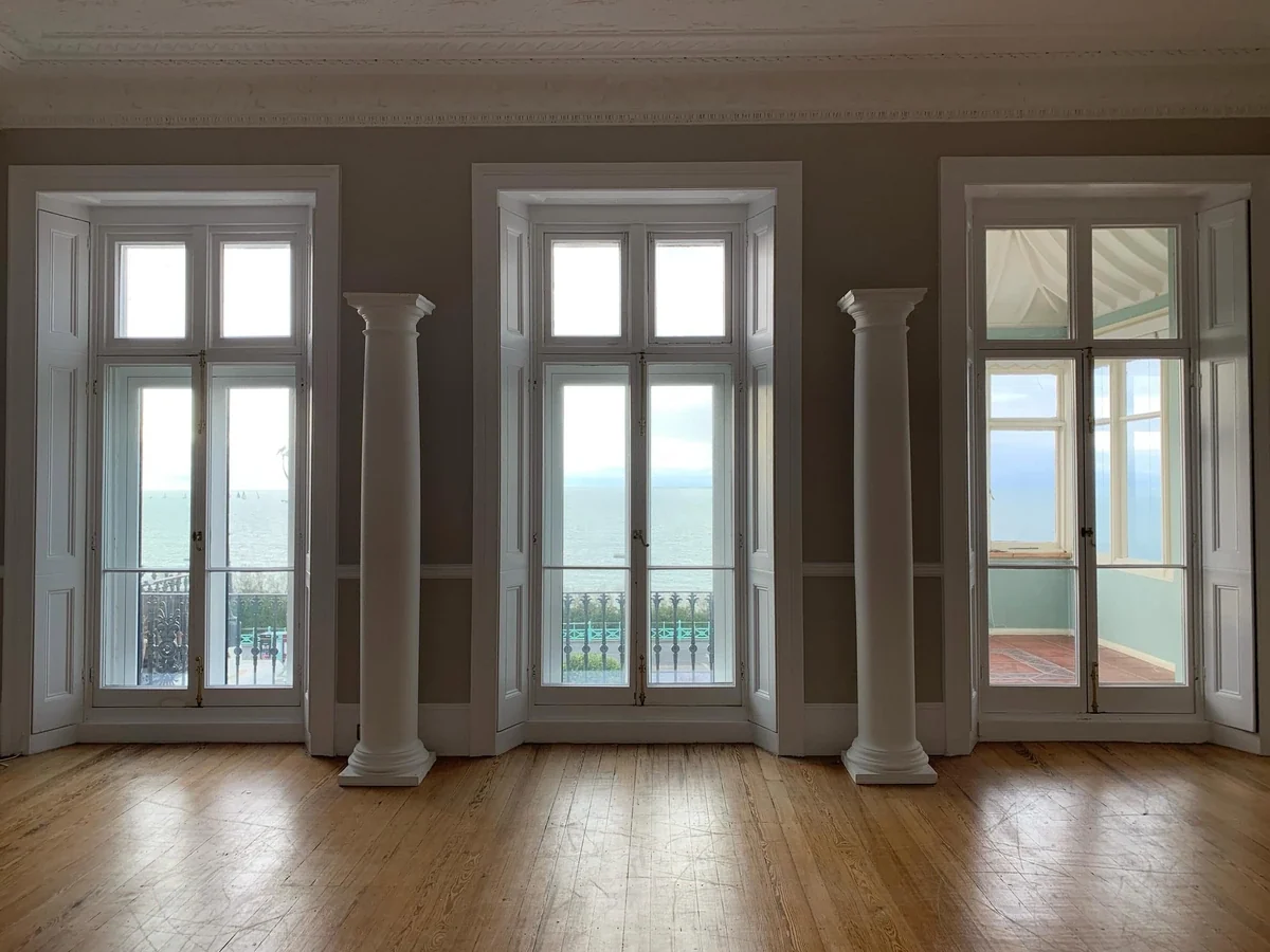 Tall period windows and columns in a Brighton seafront house looking out over the sea