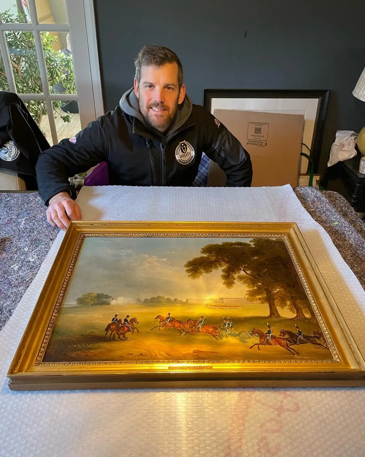 Carrying a gilt-framed landscape painting for a move in Horsham, West Sussex
