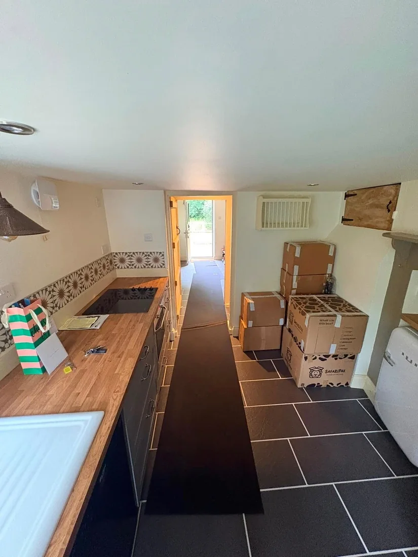 A galley kitchen in a Chichester house being packed into cartons with floor protection laid along the run