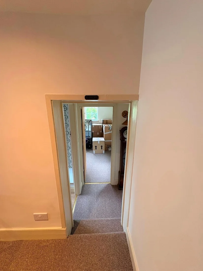 A low period doorway with a timber head beam inside a cottage during a house move