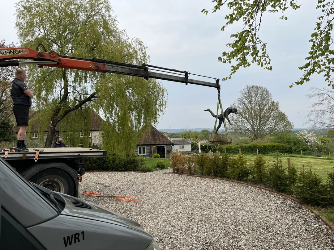 Crane loading a statue onto a trailer in Horsham