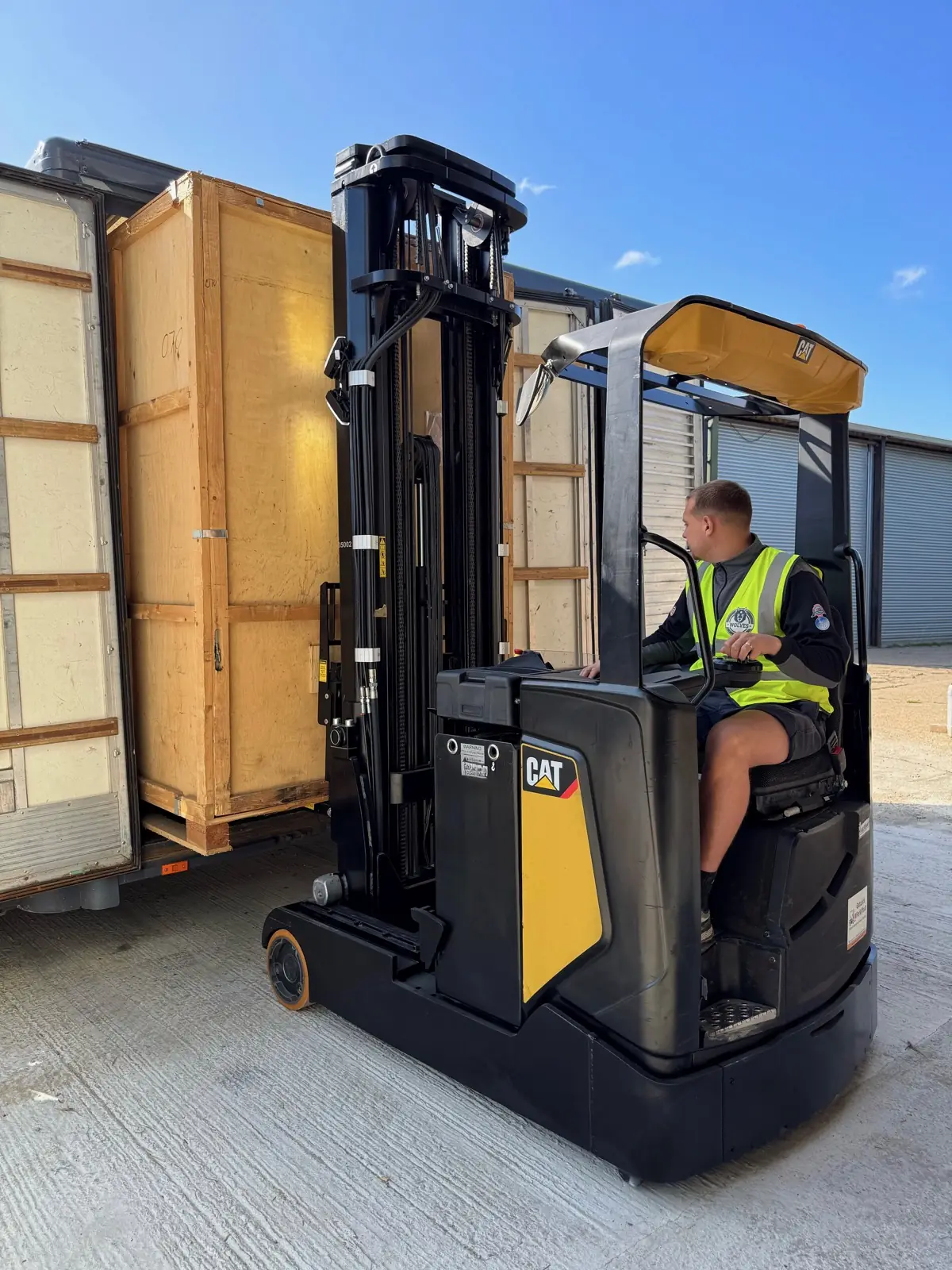 A forklift loading a wooden storage container at the Wolves Removals store