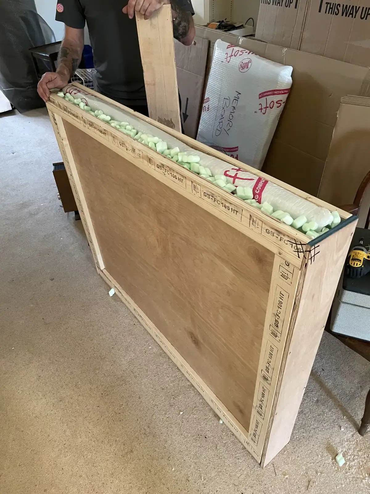 A framed mirror secured inside a made-to-measure wooden crate