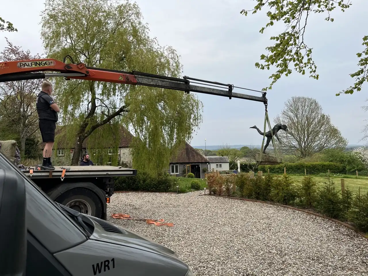 Hoisting a bronze garden statue during a move in Pulborough, West Sussex