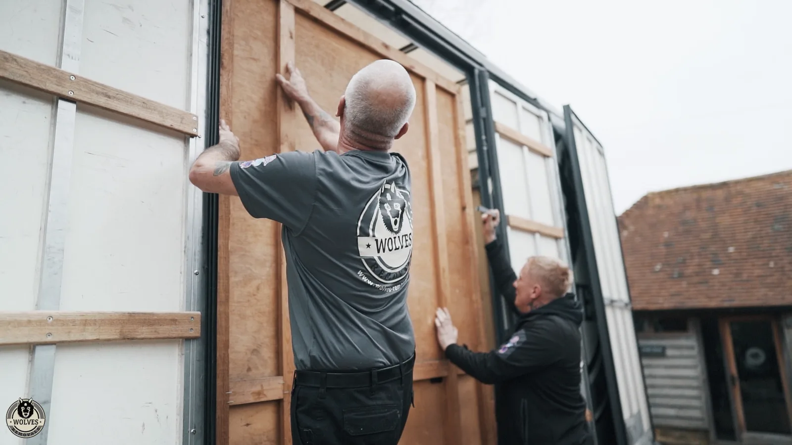 A Wolves Removals crew loading a wooden crate into the van
