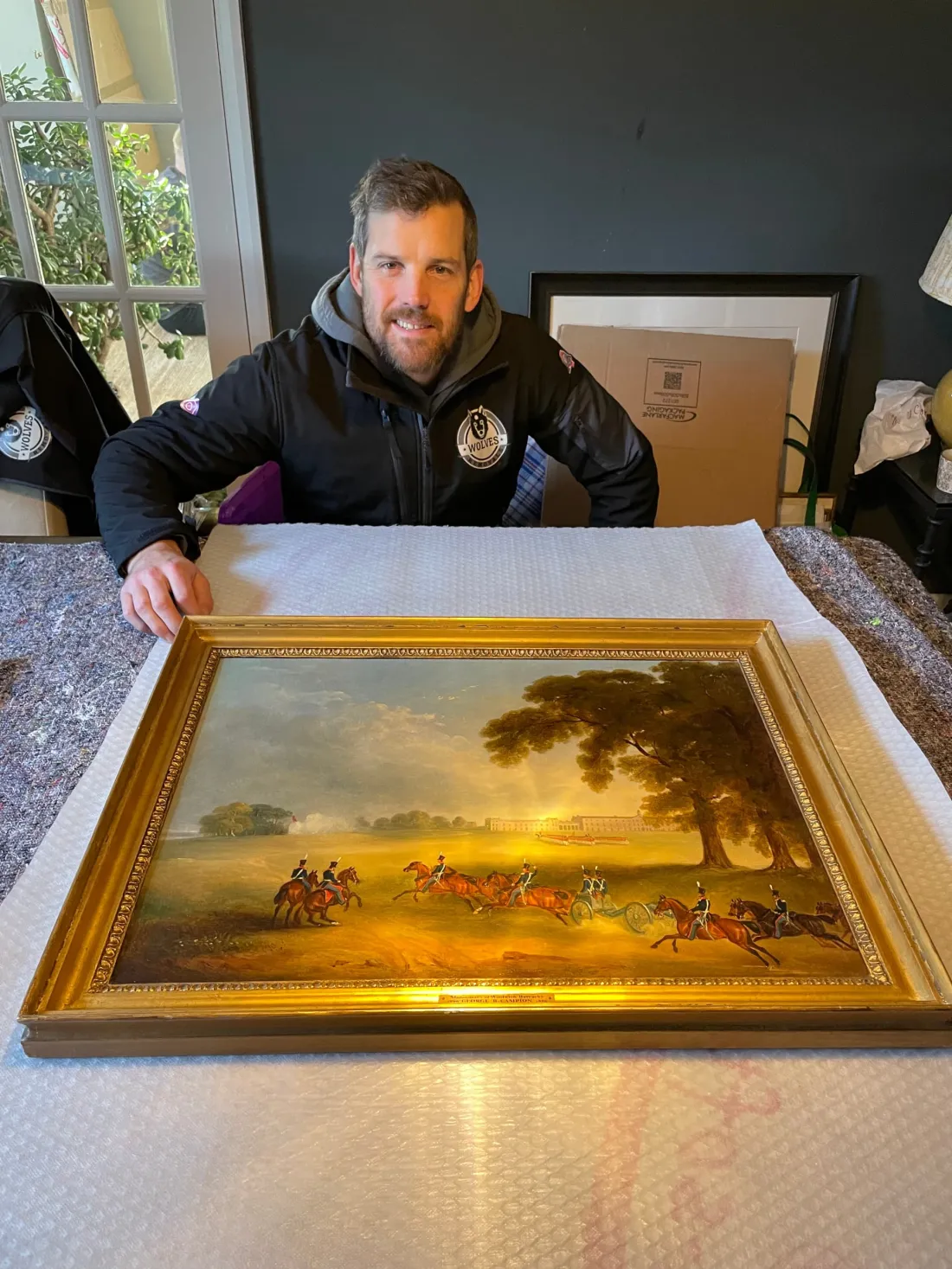 A Wolves Removals mover wrapping a gilt-framed painting for a Sussex move