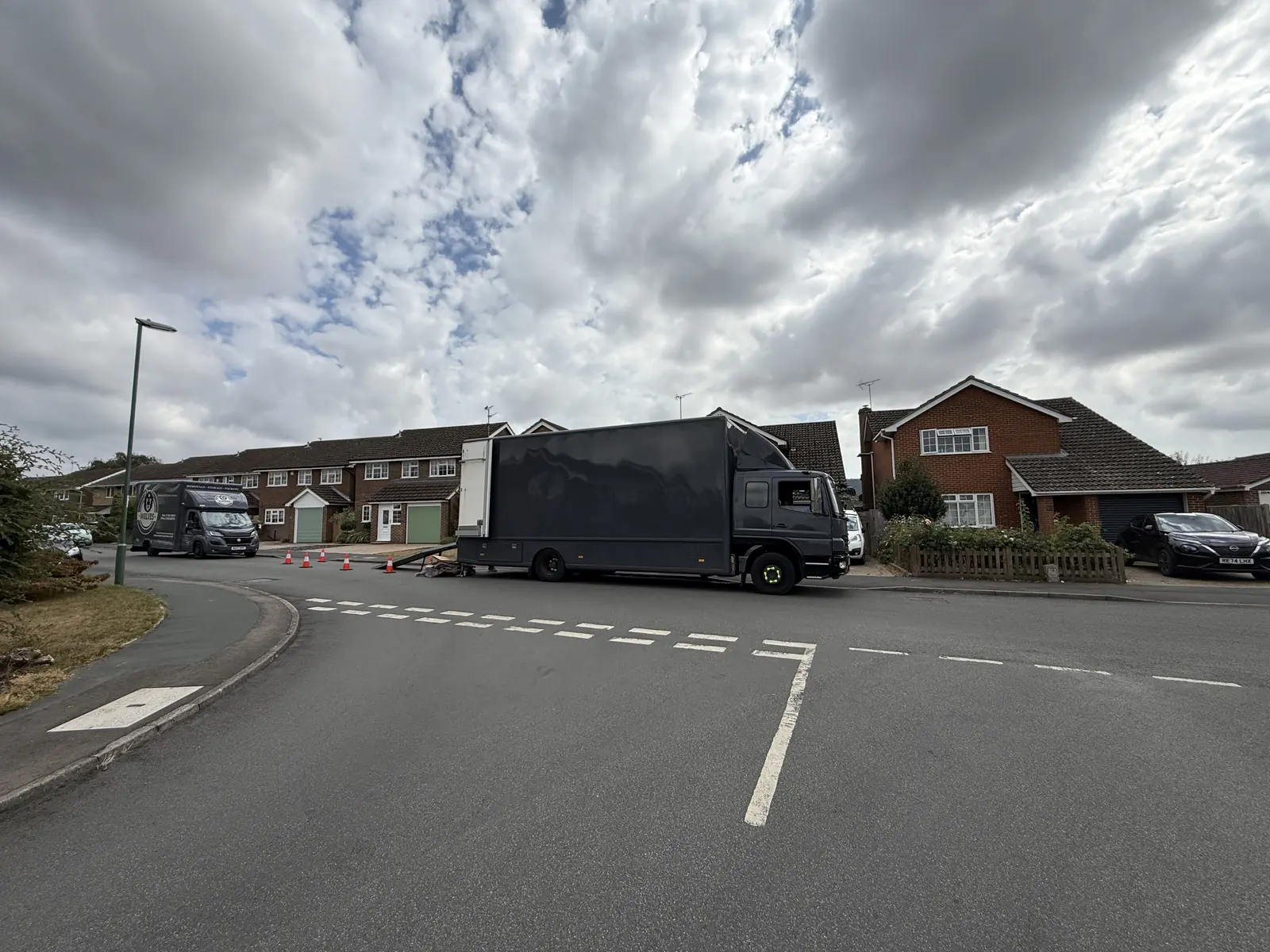 Wolves Removals lorry and branded van at the delivery address in Storrington with cones out