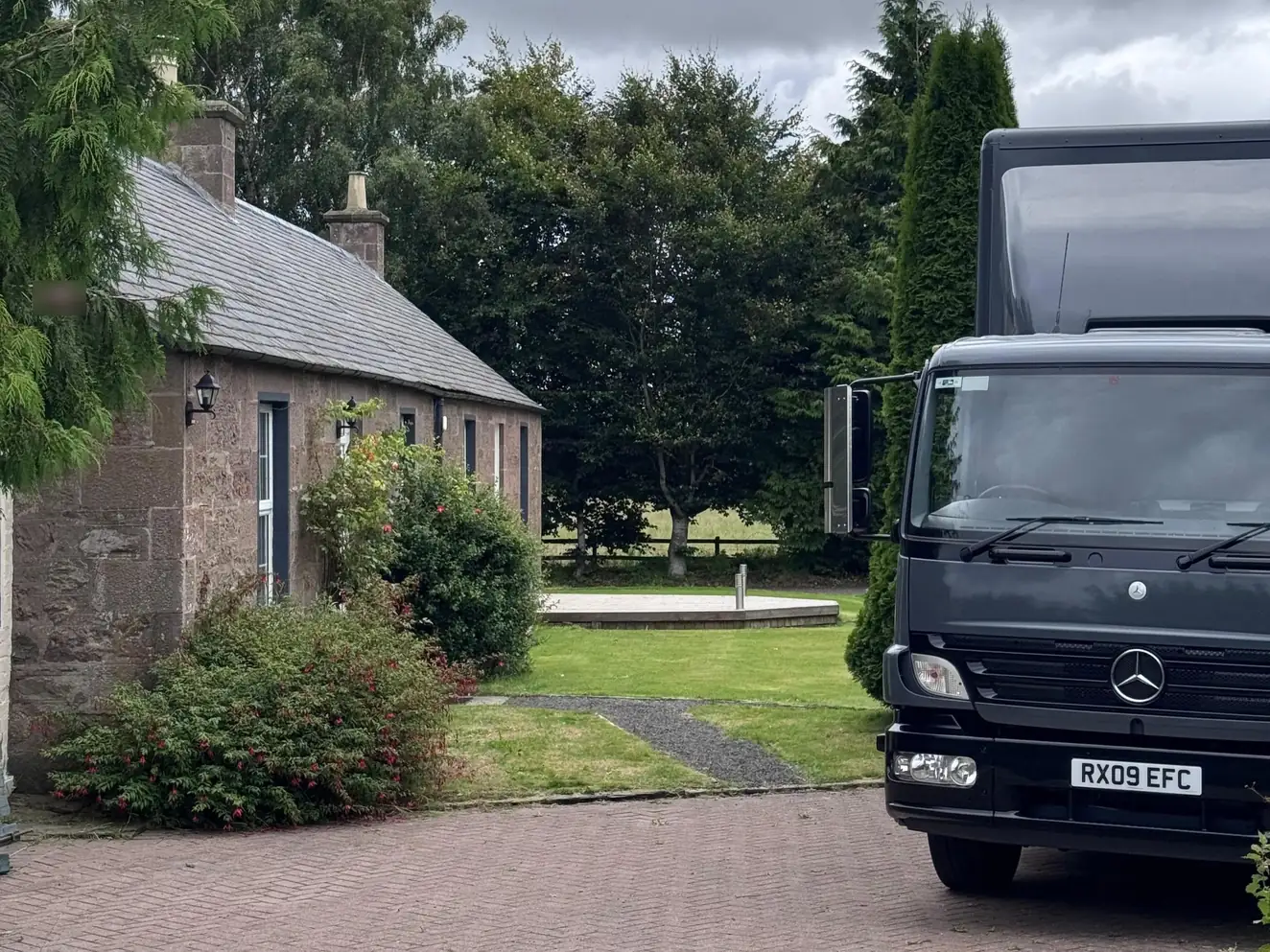 A Wolves Removals lorry parked beside a stone cottage in Perthshire on delivery day