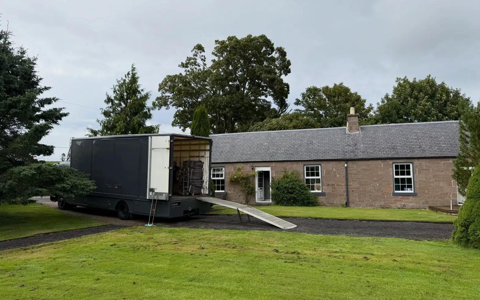 A Wolves Removals lorry with its ramp down at a stone cottage in Perthshire