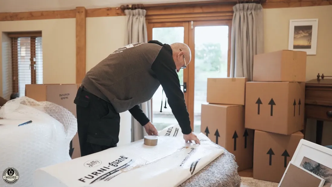 Wrapping and packing belongings among moving boxes at home
