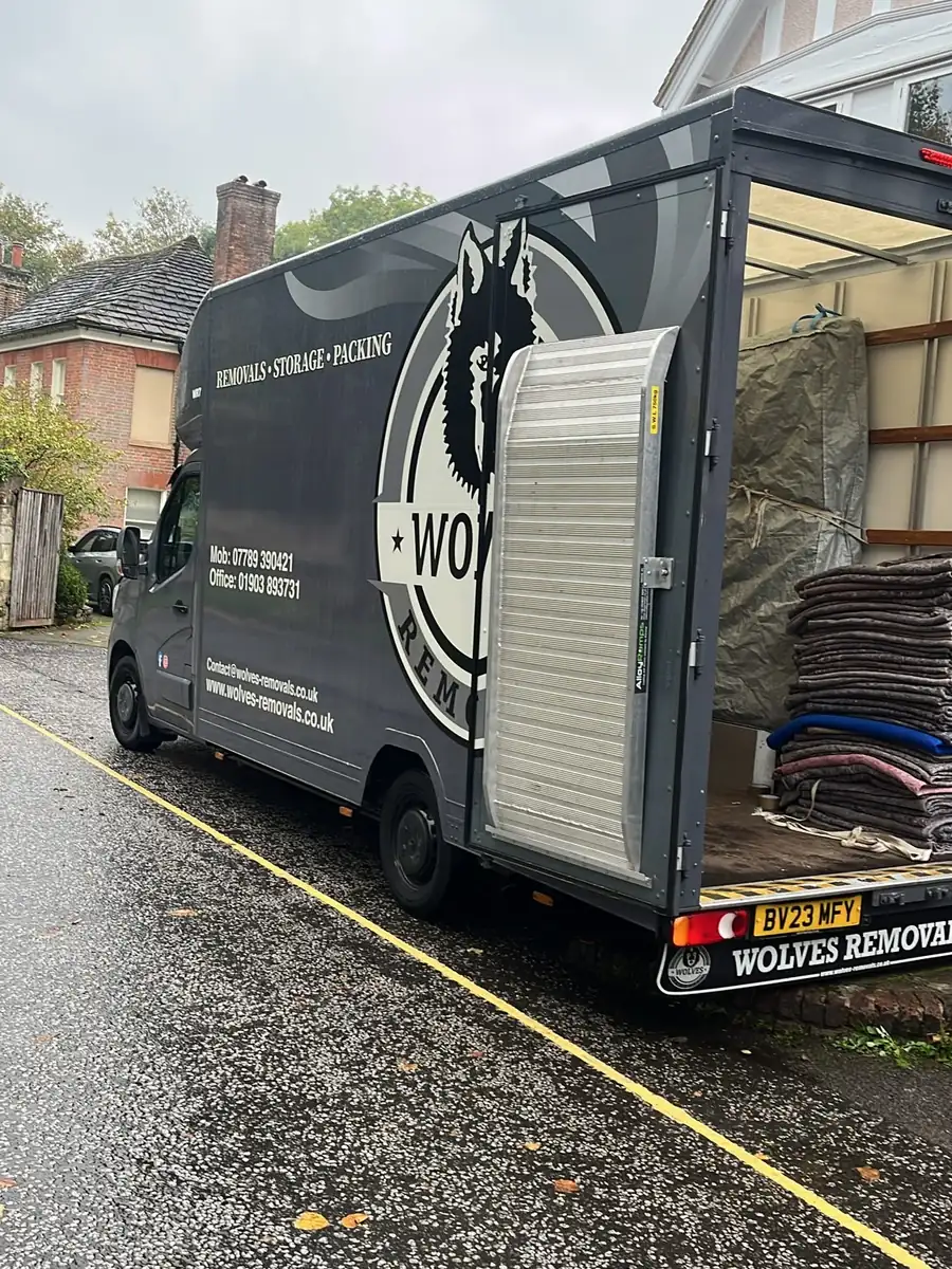 Grey Wolves Removals Luton van, back open, with a loading ramp and stacked furniture blankets