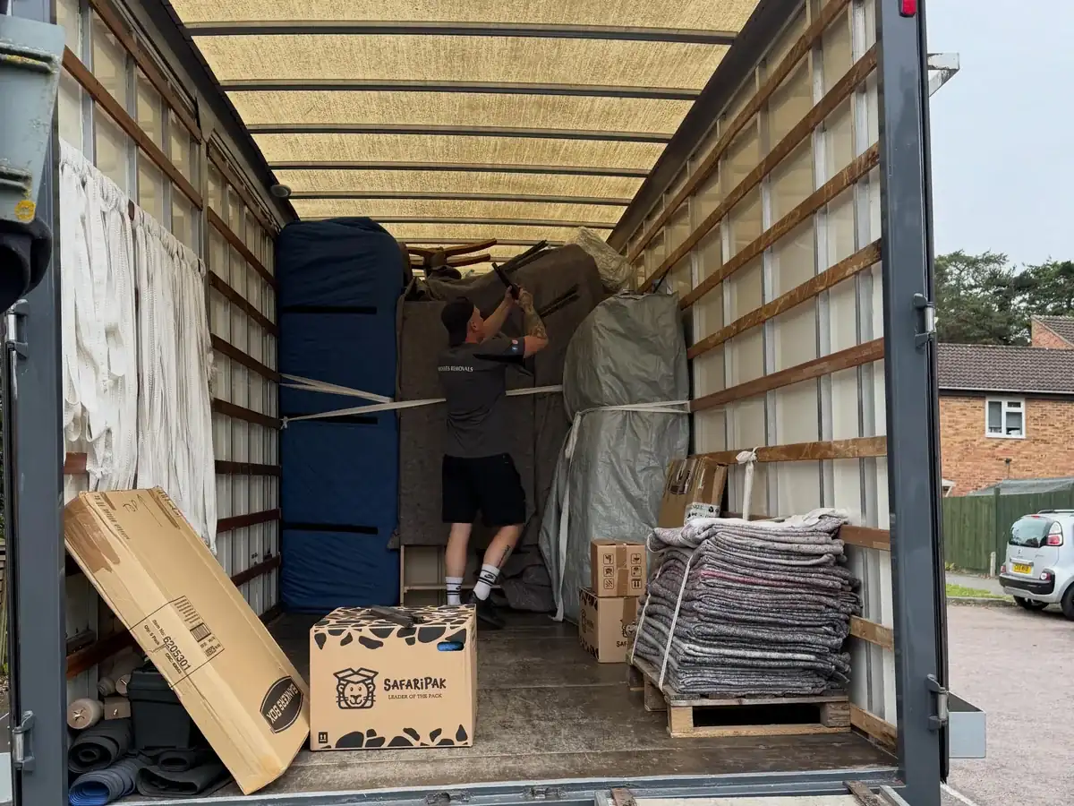 A Wolves Removals crew member strapping and securing a load inside the lorry