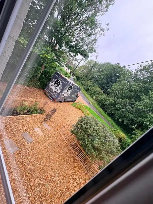 A Wolves Removals lorry on a narrow country lane outside a period cottage near Fordingbridge, seen from an upstairs window