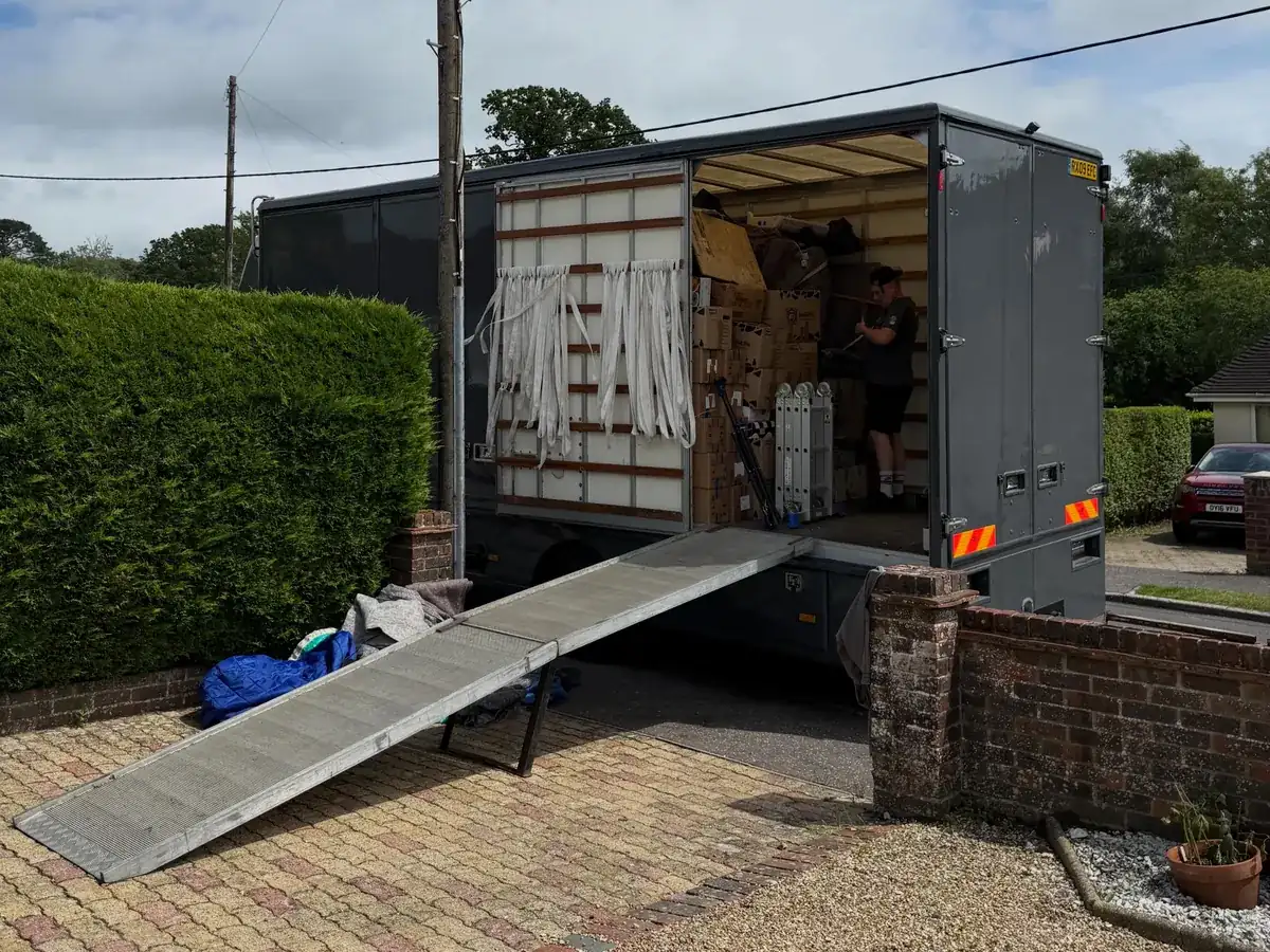 A Wolves Removals lorry with the ramp down on a block-paved driveway at the delivery address near Storrington