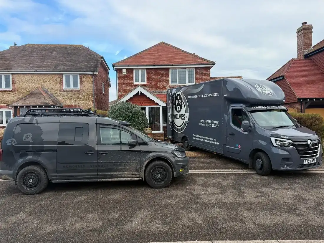 Two Wolves Removals vehicles parked on a residential street in Selsey during a delivery from storage