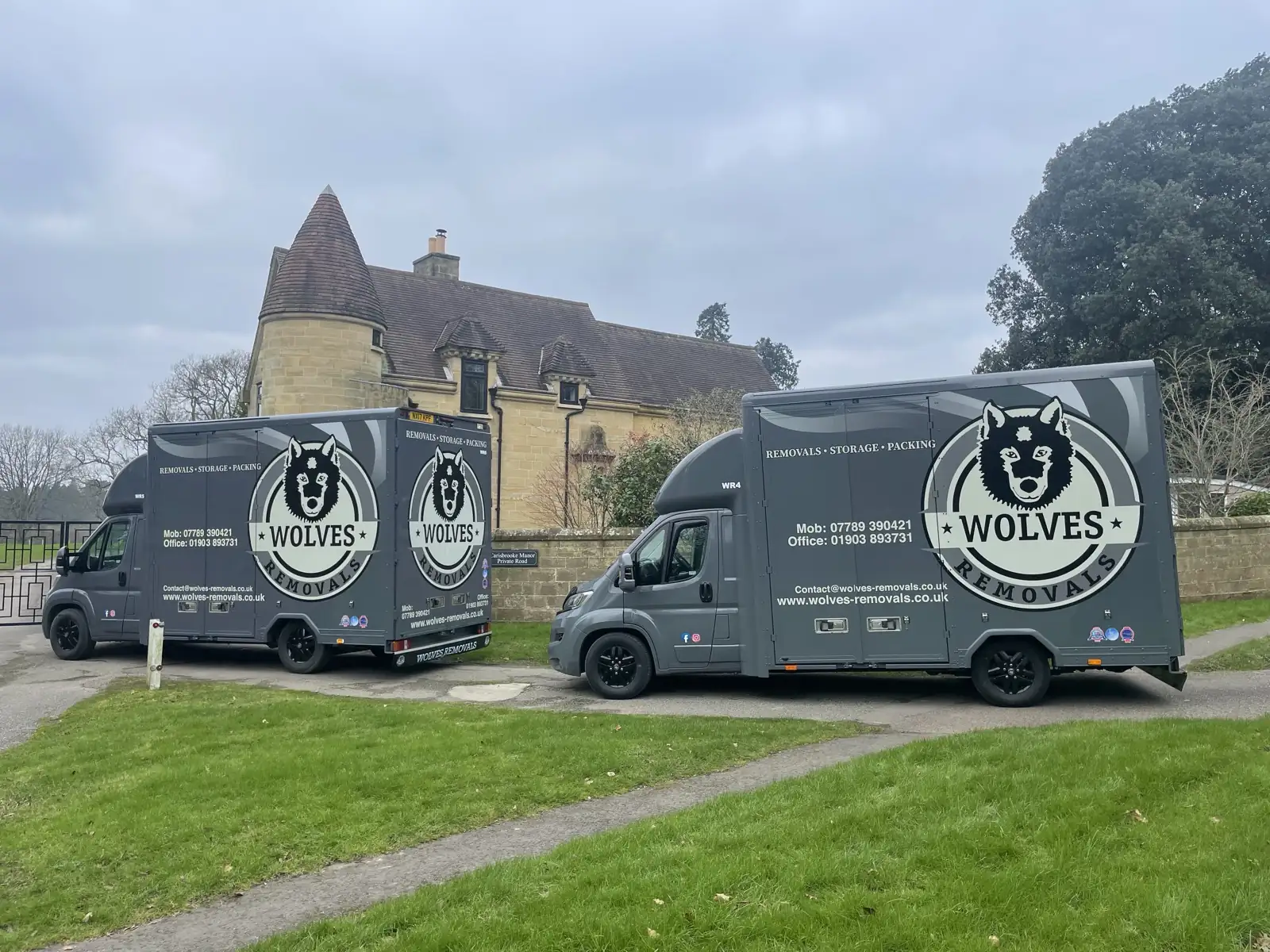 Two vans outside a country house — a Partridge Green removal