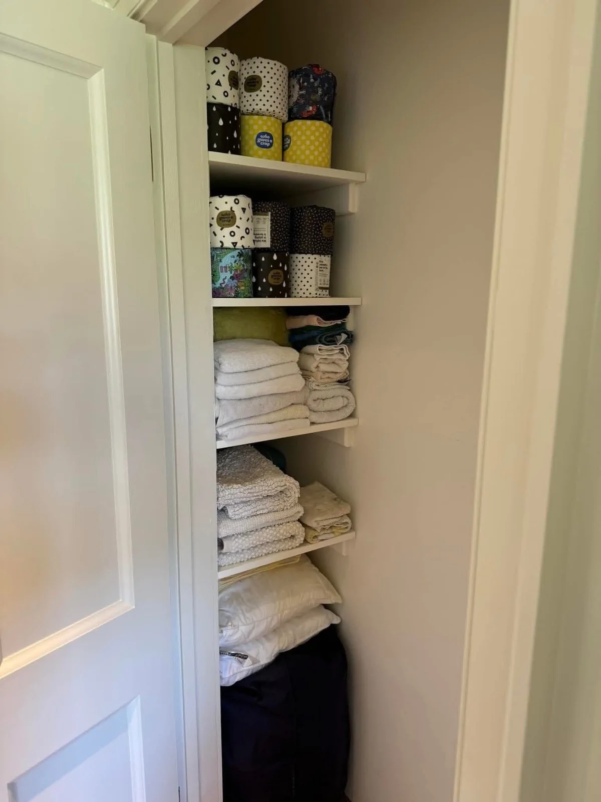 Linens and towels neatly folded and put away in a closet after a full unpacking service