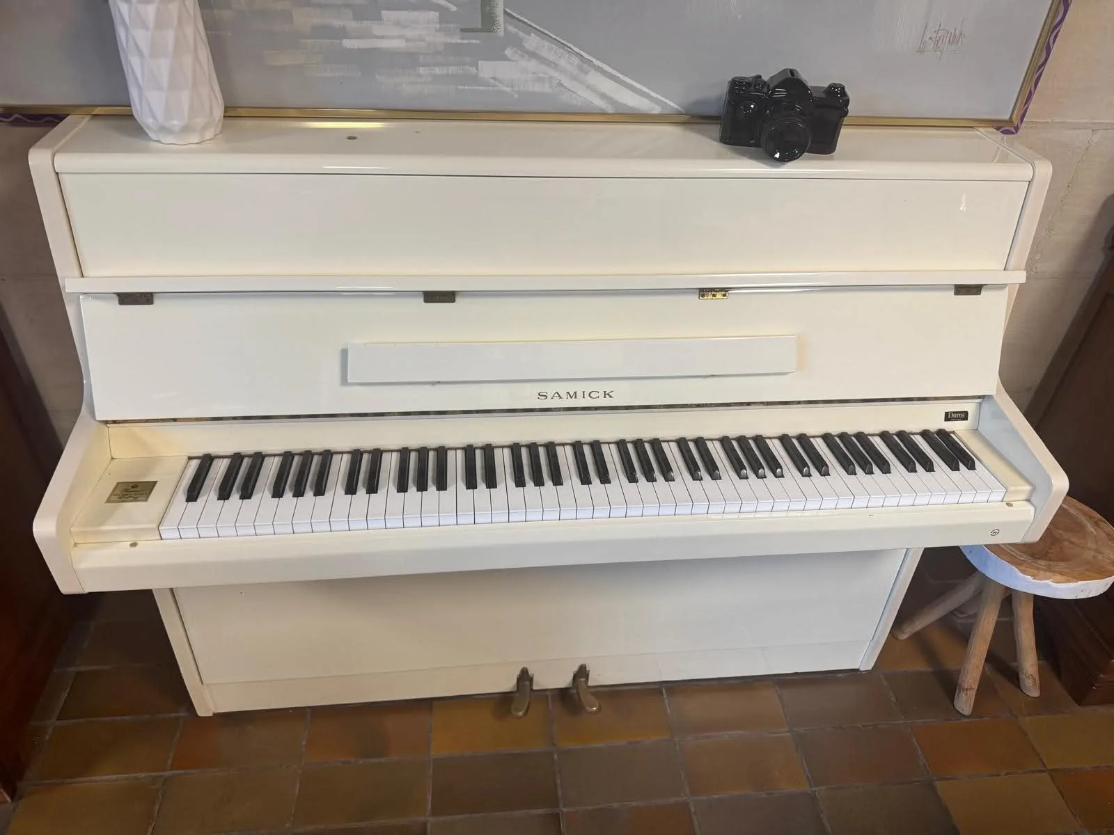 A white Samick upright piano ready for moving