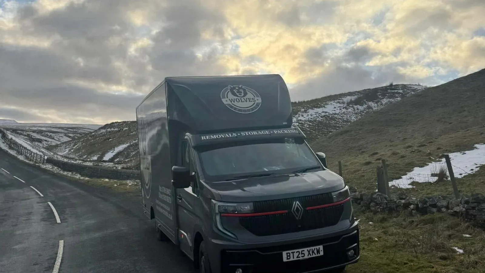 A Wolves Removals lorry on a snowy Pennine road delivering a household out of storage