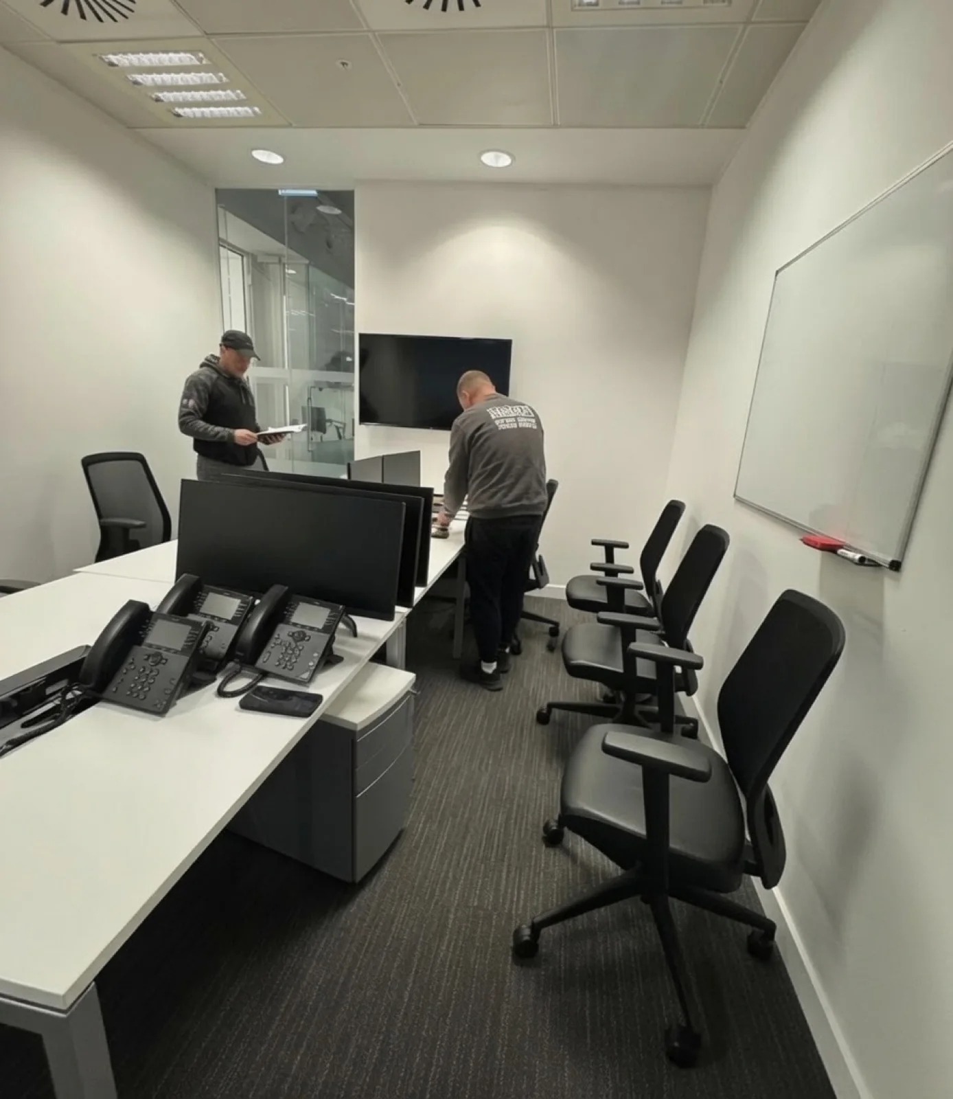 The Wolves Removals crew setting up desks and equipment in a commercial office