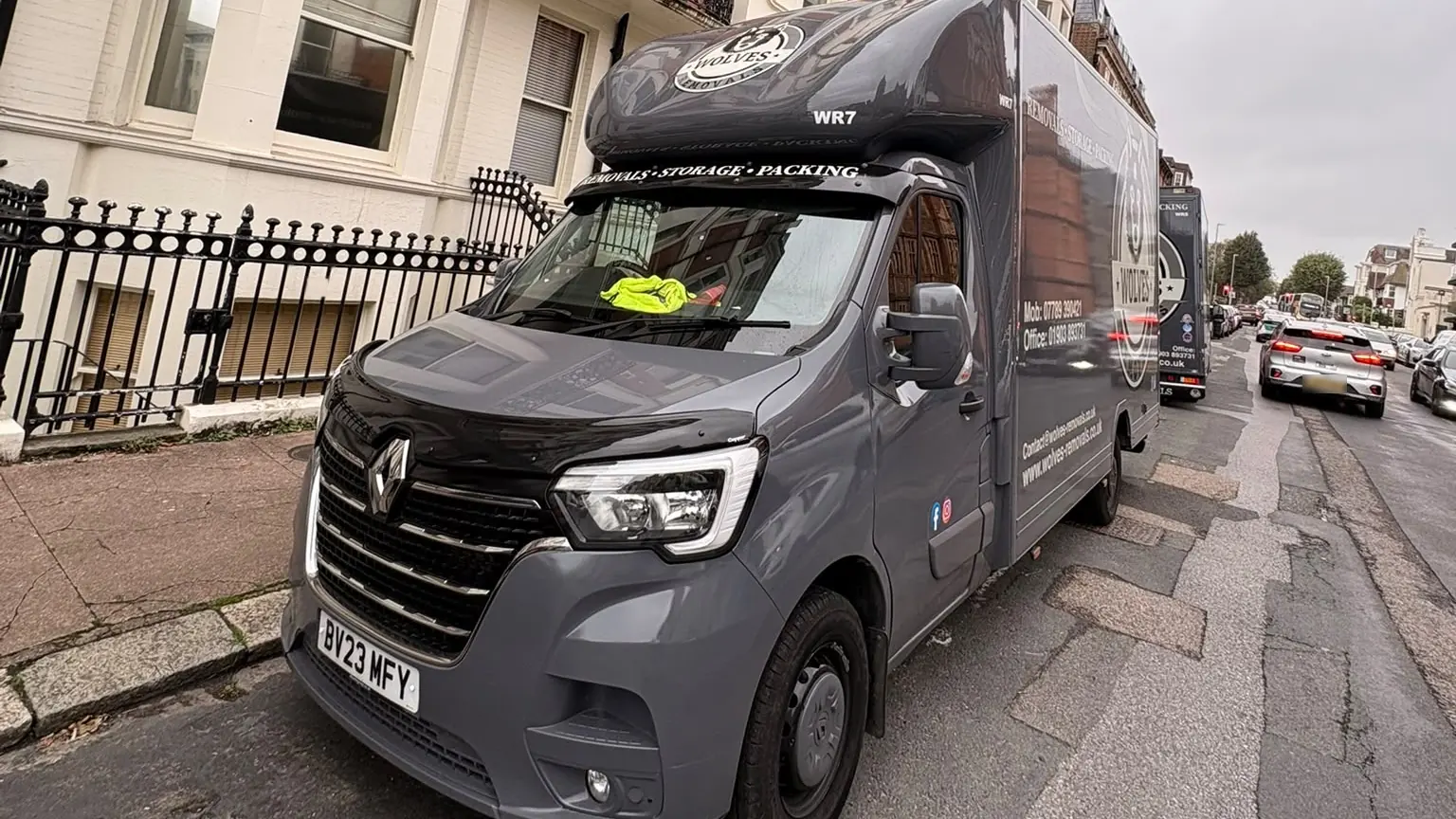 Two grey Wolves Removals vans parked on a Hove street on the day of the move