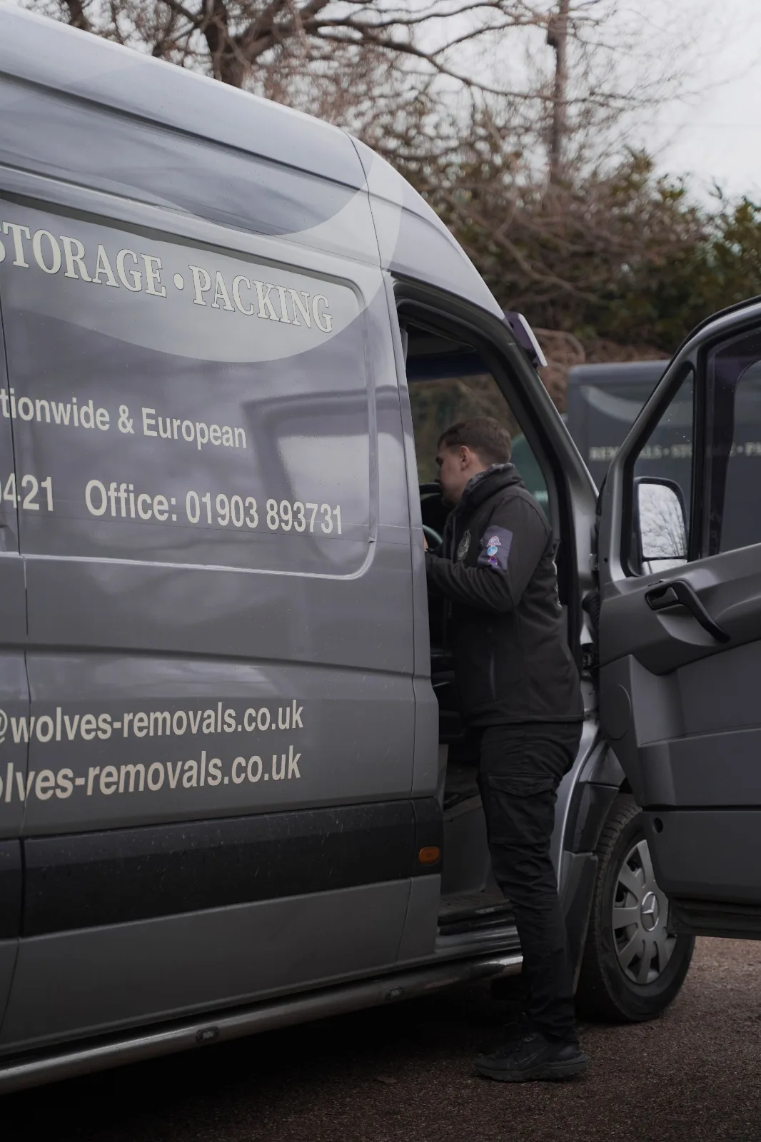 Crew member at the door of a Wolves van on a house move in Pulborough