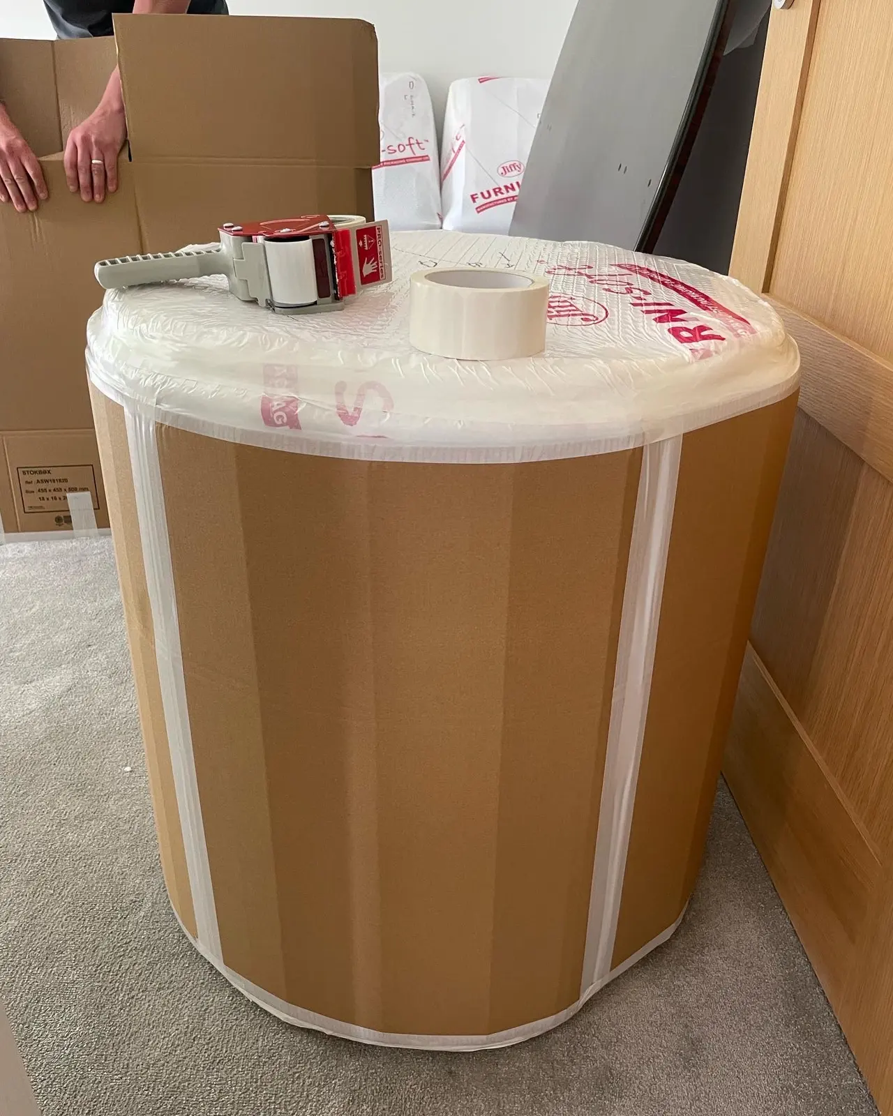 Large round table wrapped in protective covering